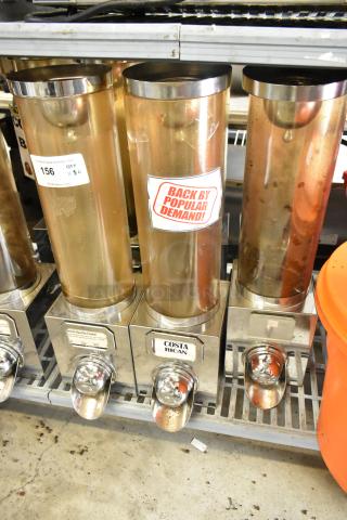 6 metal dry dispensers with transparent chambers and metal base. Labels read "Costa Rican" and "French Vanilla Cream." Used condition.