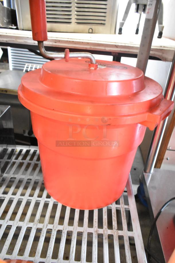 Red poly lettuce spinner, robust plastic, manual crank, lightly used condition, stackable lid, ideal for commercial kitchens.