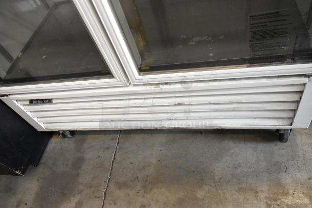 Turbo Air TGF-49F commercial freezer with two glass doors, metal finish, poly-coated racks, on casters; label visible.