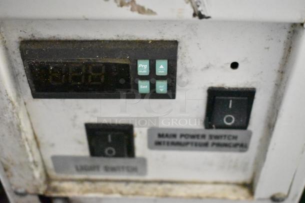 Control panel of Structural Concepts HV38RSS Merchandiser with buttons for settings and main power switch. Some wear visible.
