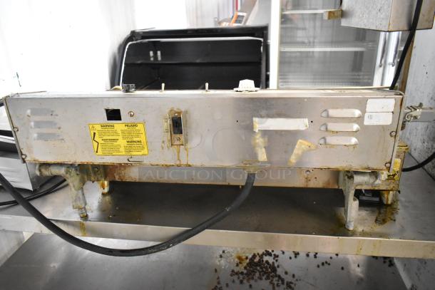 Belshaw Mark II Stainless Steel Commercial Countertop Donut Robot with visible wear, warning label, and attached power cable.