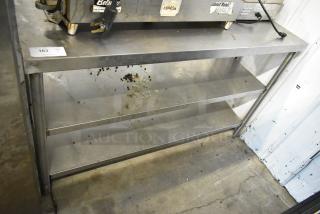 Stainless steel table with two under shelves, used condition, minor surface debris, suitable for storage or kitchen use.