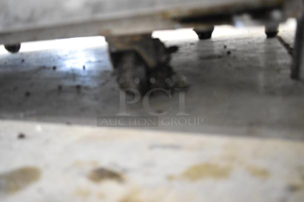 Blurry image showing a caster wheel under a commercial appliance. No clear view of the Hoshizaki RHZ-AAC cooler details.