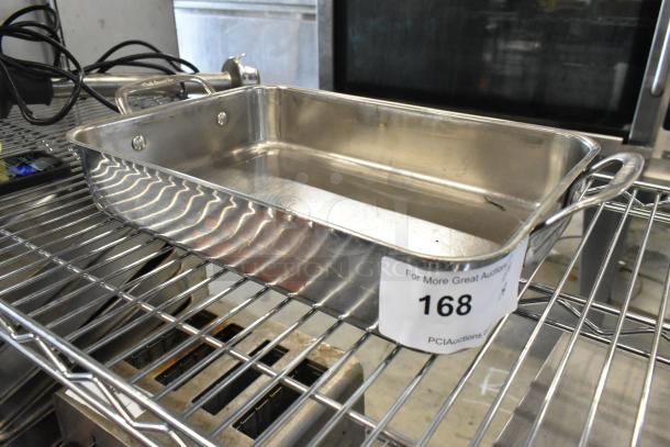 Cuisinart metal baking pan on a wire rack, stainless steel, dual handles, auction label 168 visible, excellent condition.