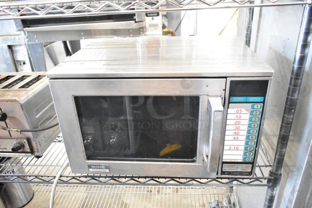 Sharp R-23GT-F stainless steel commercial microwave oven, 208/230 volts, 1 phase. Visible control panel and branding.