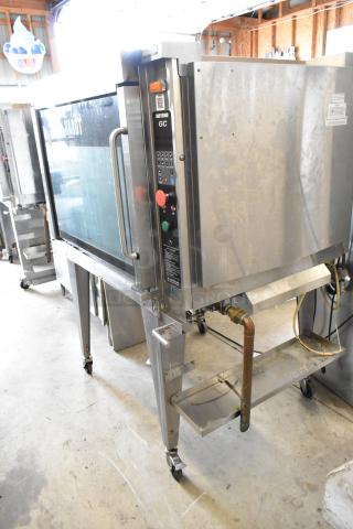 Hardt GC/4000 stainless steel rotisserie oven, natural gas powered, on metal legs with commercial casters.