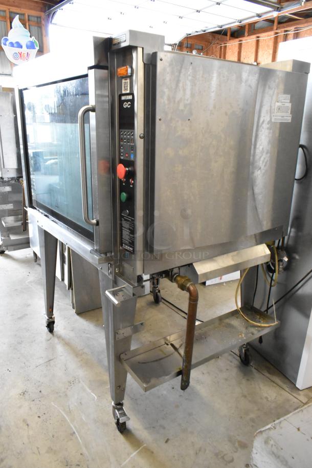 Hardt GC/4000 stainless steel rotisserie oven on metal legs with casters. Commercial gas-powered, visible controls, used condition.
