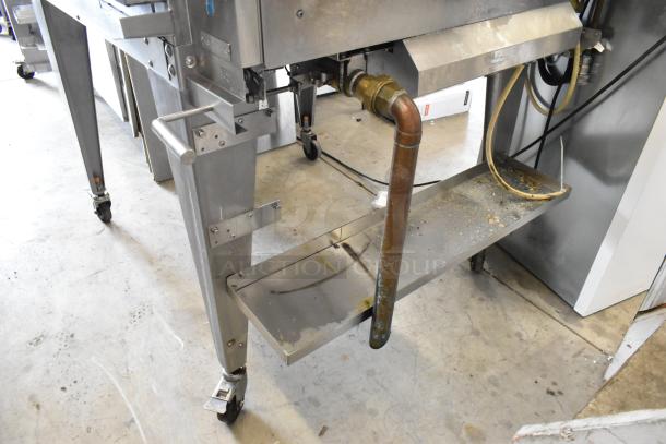 Hardt GC/4000 stainless steel rotisserie oven, natural gas, on metal legs with commercial casters, visible piping.