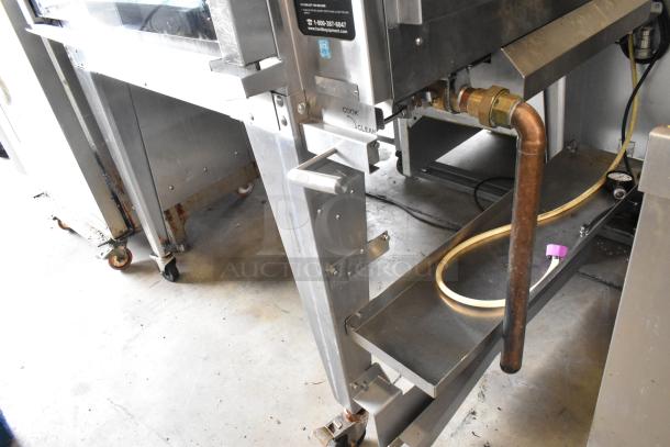 Hardt GC/4000 rotisserie oven, stainless steel, natural gas powered, on metal legs with casters, visible connection pipe.