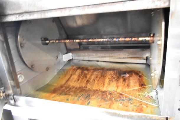Hardt GC/4000 Stainless Steel Rotisserie Oven, Commercial Grade, Natural Gas, on Metal Legs with Casters, Shows Wear.