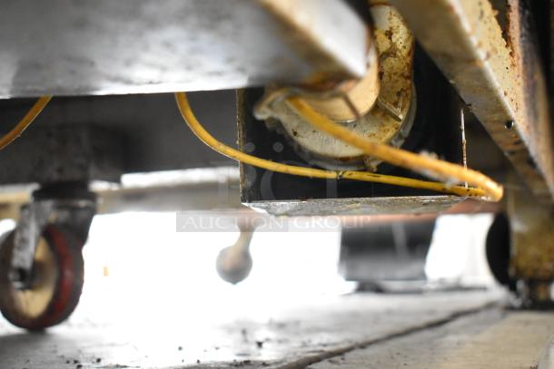 Close-up view of the underside of an Alto Shaam 12.20ESI-SK convection oven, showing electrical components and wheels.