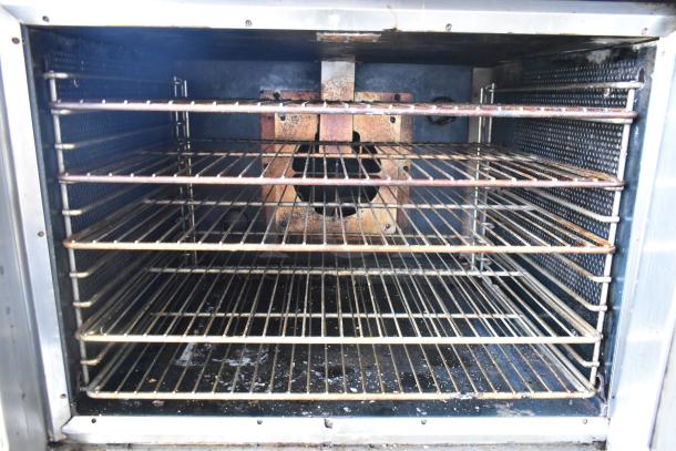 Vulcan SG4D-1 stainless steel convection oven interior with metal racks. Bottom doors are stuck. View-through doors visible.