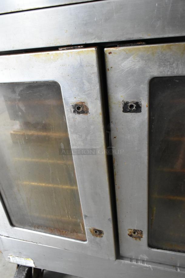 Vulcan SG4D-1 stainless steel convection oven with view-through doors, metal racks, thermostatic controls, on casters. Bottom doors stuck.