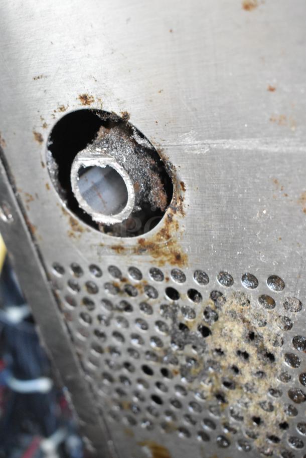 Close-up of a corroded metal surface on a Vulcan SG4D-1 convection oven. Visible rust and wear around a circular opening.