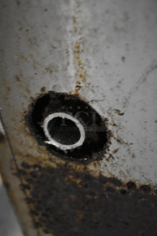 Close-up of rusted metal surface with a circular hole, related to Vulcan SG4D-1 convection oven issue.