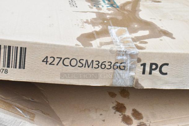 Cardboard box labeled "427COSM3636G 1PC" with visible water stains. Contains new Lancaster Table & Seating 36" square table.