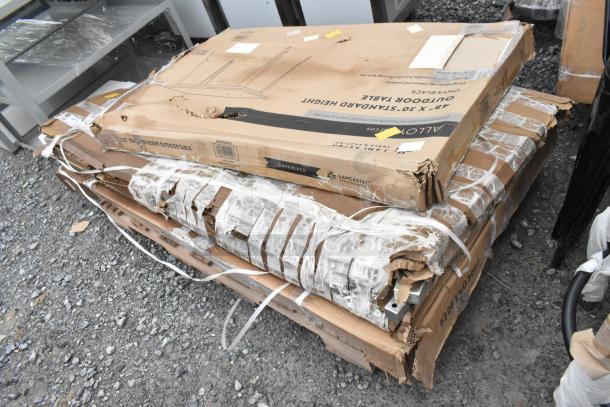 Three new "scratch and dent" items including a stainless steel table, black outdoor table, and chair frames in original packaging, visible wear on boxes.