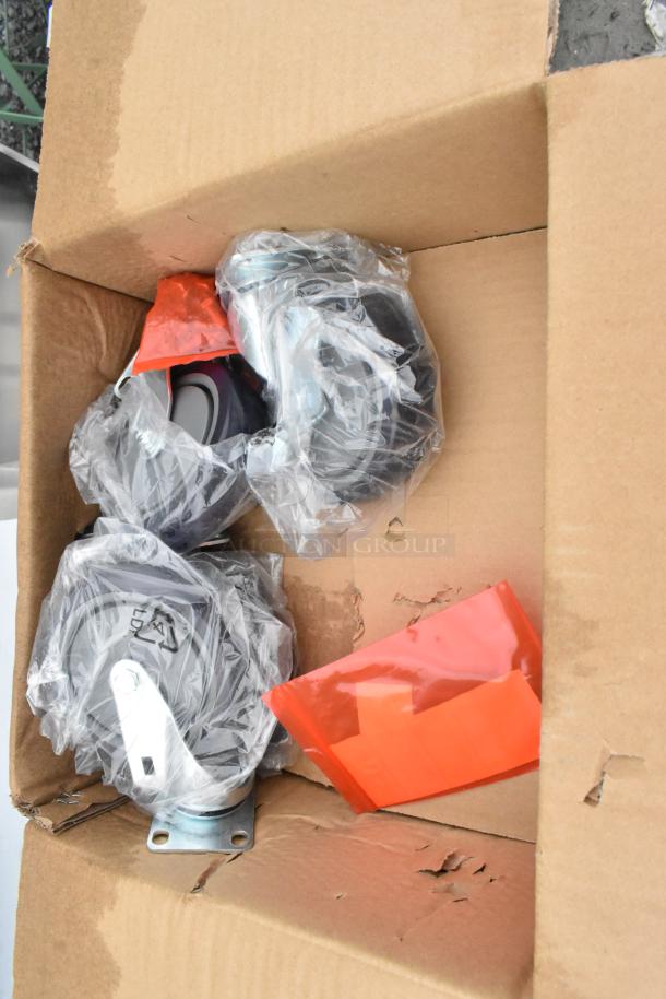 Cardboard box containing wrapped caster wheels for Regency 600PHS24HC Hand Sink Cart, with visible scratch and dent damage.