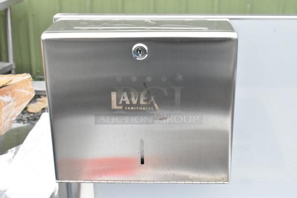 Stainless steel Lavex Janitorial dispenser on Regency sink cart. Visible scratches; new condition despite marked imperfections.