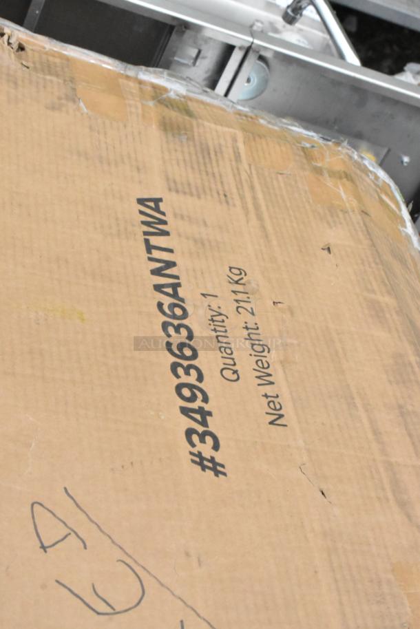 Cardboard box displaying "#3493636ANTWA, Quantity: 1, Net Weight: 21 Kg" with slight wear visible. Auction item packaging.