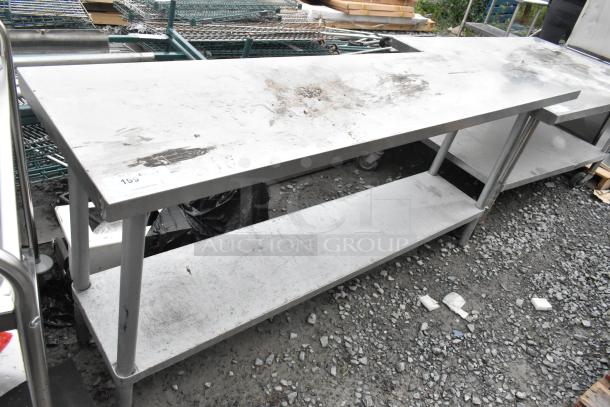 Stainless steel table with metal under shelf, used condition, surface wear, ideal for commercial use.