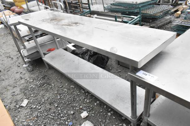 Stainless steel table with metal under shelf, showing signs of wear. Includes item tag indicating product details.