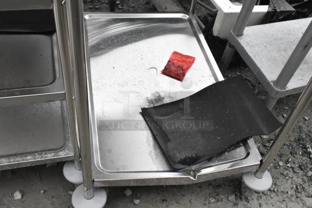 Stainless steel cart with two tiers and commercial casters. New condition, shows visible scratches and dents.
