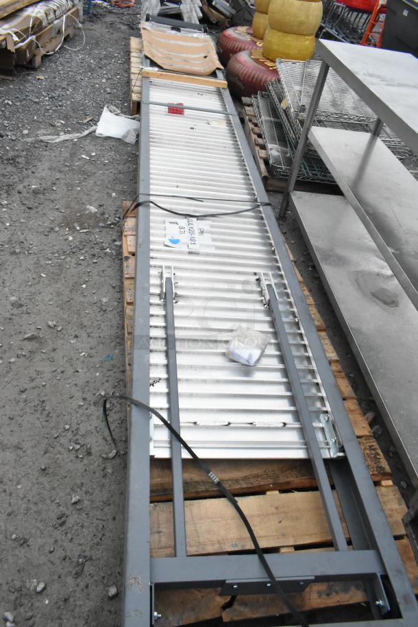BRAND NEW SCRATCH AND DENT Magliner SR2416 2400 Series 16' Slider Ramp on pallet; minor surface imperfections visible.