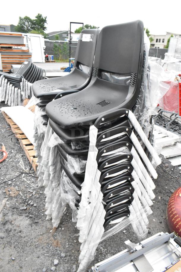 Stack of 20 brand new black poly and metal chairs, scratch and dent condition, wrapped; outdoor setting.