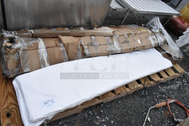 Four brand new Regency stainless steel items with packaging damage, including work table and heavy-duty wall shelf, visible on pallet.