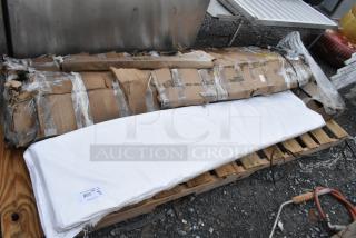 Four brand new Regency stainless steel items with packaging damage, including work table and heavy-duty wall shelf, visible on pallet.