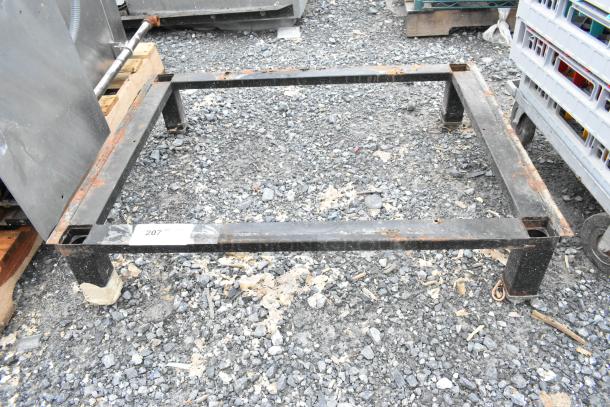 Black metal stand with visible rust and wear, numbered tag "207," suitable for industrial use or repurposing.