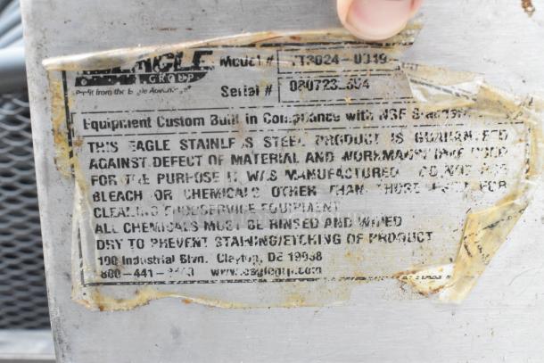 Label on stainless steel tabletop, Eagle Group model T3024-U119, serial 080723-354. Custom built, NSF certified, and material guaranteed.