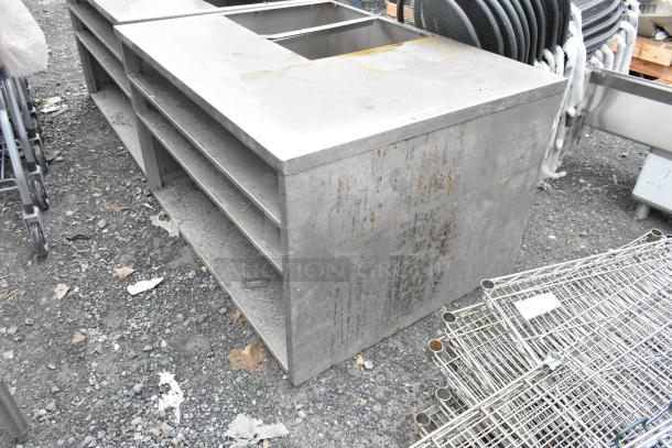 Stainless steel counter with cut out and 3 under shelves, showing surface wear and rust marks, ideal for kitchen use.