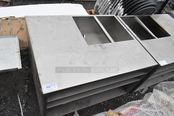 Stainless steel counter with cutout, features three under shelves. Light scratches visible. Tag with auction lot number "212."