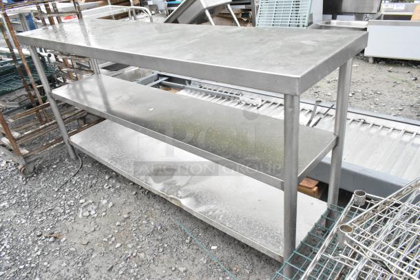 Stainless steel table with two under shelves, slight wear. Ideal for commercial kitchen use.