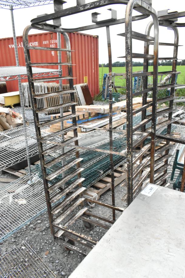 2 metal commercial pan transport racks with top guides, suitable for rack ovens, on commercial casters. Used condition.