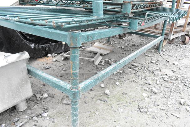 Lot of various items including a green dunnage-style shelving unit with visible rust and rough terrain setting.