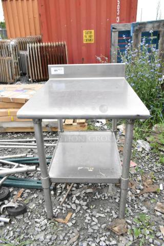 Stainless steel table with metal under shelf. Used condition, durable, has label "221" on top. Ideal for industrial use.