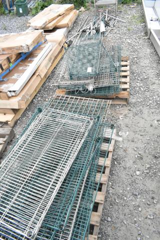 Lot of 2 pallets with various metal wire shelves and poles. Items appear used, assorted sizes and styles, stored outdoors.