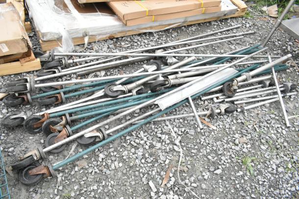 Lot of wire shelves and poles with casters, stacked on pallets, mixed condition, includes boxes and packing materials.