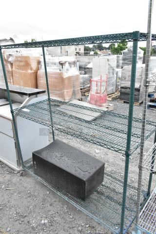 Green finish 3-tier wire shelving unit in outdoor setting. Sturdy metal construction. Requires dismantling for shipping.