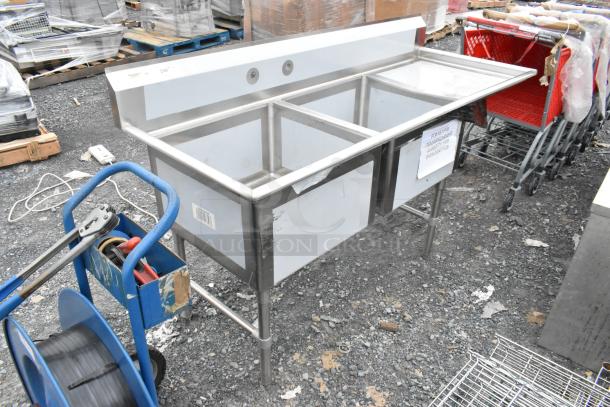 Brand new Regency 600S2242424R stainless steel 2 bay sink with right-side drainboard. Some scratches and dents visible.
