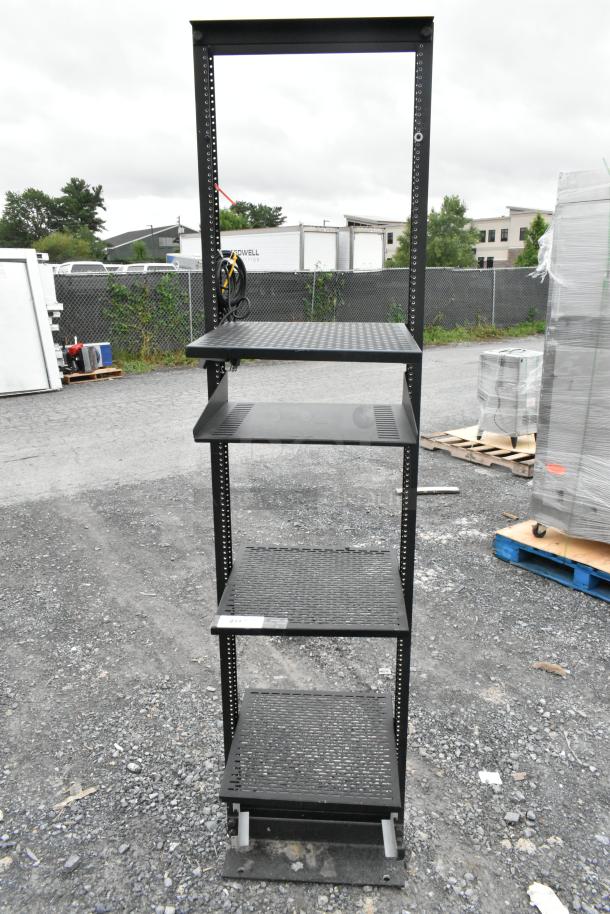 Black metal shelving unit with four perforated shelves, sturdy frame, in good condition. Ideal for storage or display.