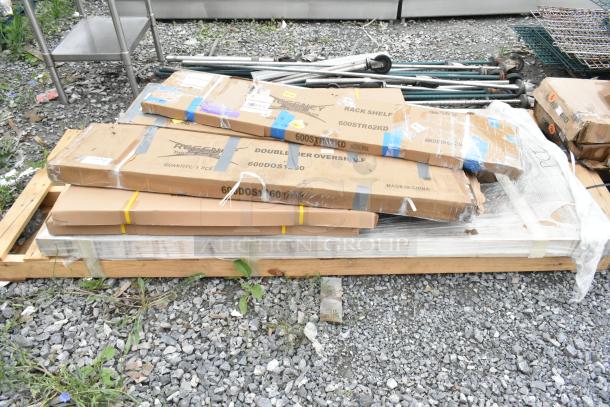 Packaged stainless steel overshelves and accessories on a pallet, labeled "REGGNEY." New condition, scratch and dent items.