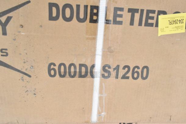 Cardboard box labeled "600DC S1260" with a yellow sticker and signs of wear. Contains new stainless steel overshelves.