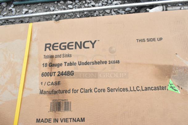 Cardboard box labeled "Regency Tables and Sinks," containing 18 gauge table undershelve, model 600UT 2448G. Box indicates "Made in Vietnam."