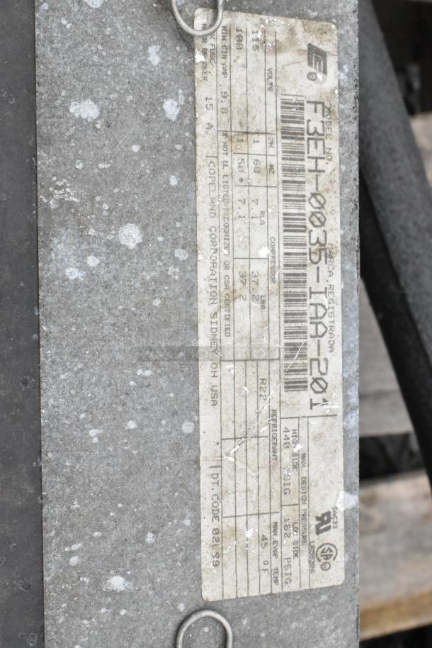 Copeland ASE26C4-IAA-959 commercial compressor, 115 volts, 1 phase. Features include attached label indicating specs.