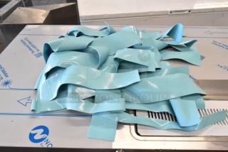 Assure Blue Dishwasher Ribbon Curtain, textured blue material, new condition, labeled "ASSURE", for industrial use.