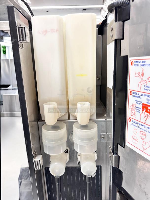 Curtis PC2D-10-02 dual flavor cappuccino dispenser, pristine condition, 120V, fully tested. Visible canisters and instructional label.